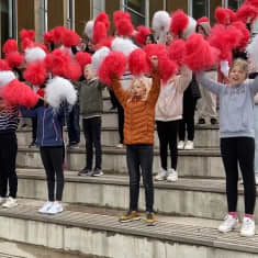 En hejarklack med vita och röda pom-poms.