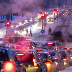 Pysähtyneitä autoja risteyksessä odottamassa liikennevalon muuttumista vihreäksi.