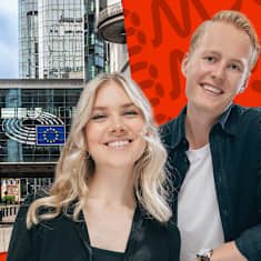 Sabina Kyllönen och Niklas Grönholm poserar framför en bild på Europaparlamentet i Bryssel. 