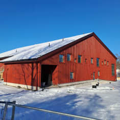 En röd skola, man ser fönster längs ena väggen. Det är Kyrkfjärdens skola i Ingå.