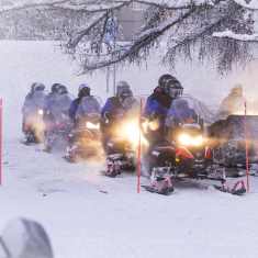 Turistit lähdössä moottorikelkkasafarille.