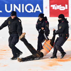 Demonstranter förs bort från målområdet.