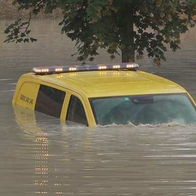 En bil under vatten i översvämning.