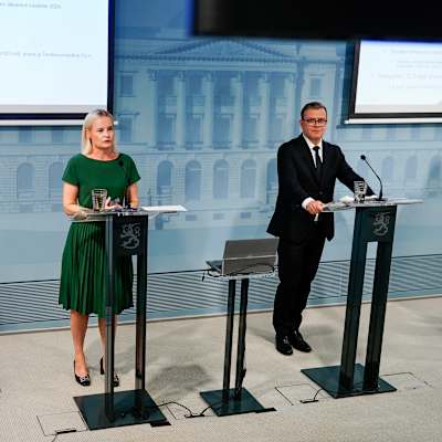 Sari Essayah, Riikka Purra, Petteri Orpo och Anders Adlercreutz står på rad vid varsin talarstol under en presskonferens.