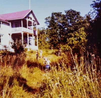 En vit villa med rött tak. Barn framför villan. Fotot taget på 1970-talet.