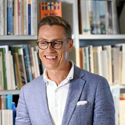 President Stubb framför en bokhylla på presskonferens.