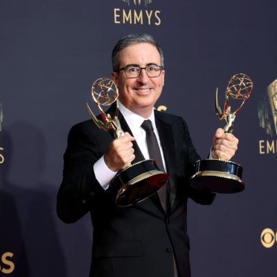 John Oliver poserar med två Emmystatyetter.