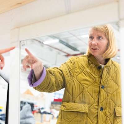 Konstnären Sara Bjarland pekar mot sin egen spegelbild.