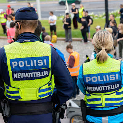 Två poliser står vid en demonstration.