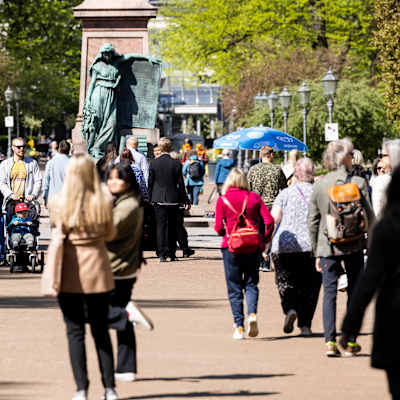 Människor går i solen i Esplanadparken.