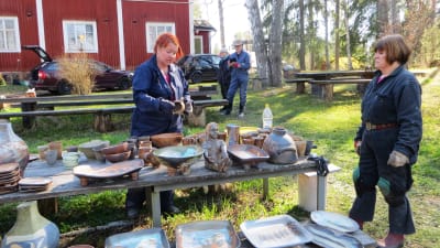 Keramiker Elina Sorainen tillsammans med kollegerna Pia Vuorinen och Ritva Turunen granskar resultatet av den senaste keramikugnsbränningen