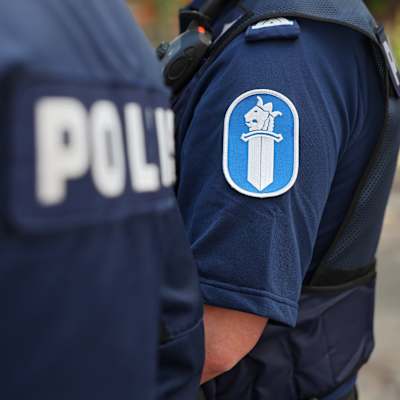 Två anonyma poliser i uniform. Endast överkroppen syns.