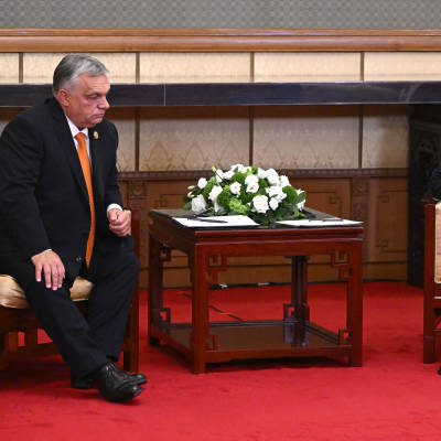 Ungerns premiärminister Victor Orban sitter till vänster och på stort avstånd sitter Rysslands president Vladimir Putin.