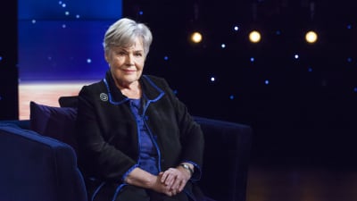 Elisabeth Rehn sitter i en blå sammetsfåtölj hos Daniel Olin. 