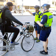 poliisit neuvomassa pyöräilijää