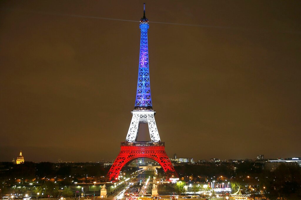 The Eiffel Tower is lit with the blue, white and red colours of the French flag in Paris to pay tribute to the victims of a series of deadly attacks on Friday in the French capital