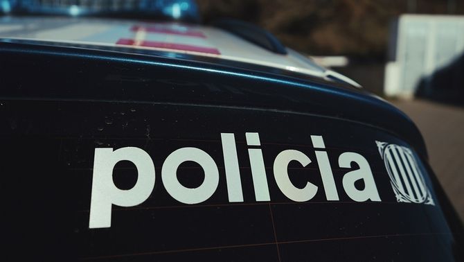 Un cotxe dels Mossos d'Esquadra, en primer pla, amb les lletres Policia