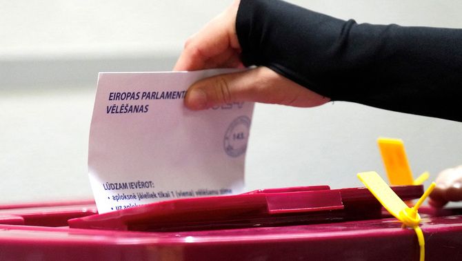 Una dona diposita un vot a l'urna de les eleccions europees a Letònia