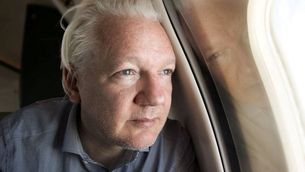 Julian Assange mira per la finestra de l'avió