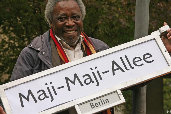 Mnyaka Sururu Mboro, of nonprofit Berlin Postkolonial, holds a sign for a street renamed to commemorate a rebellion in German East Africa. 