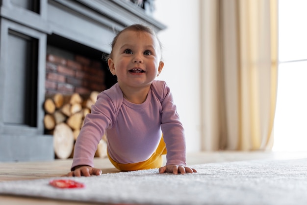 Free photo adorable baby playing with toy at home on the floor