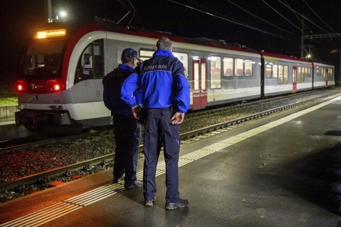 Des gendarmes devant un train dans lequel quinze personnes ont été prises en otages, dans le canton de Vaud, en Suisse, le 8 février 2024.