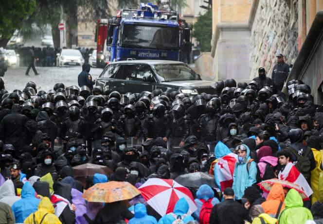 Des parlementaires pénètrent dans le Parlement derrière un mur de policiers, lors d’une manifestation contre un projet de loi sur l’« influence étrangère », à Tbilissi, Géorgie, 13 mai 2024. 