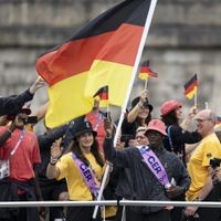 Anna-Maria Wagner (links) und Dennis Schröder als Fahnenträger bei der Eröffnungsfeier der Olympischen Spiele in Paris. Der Basketballer hat heute seinen ersten sportlichen Auftritt. 