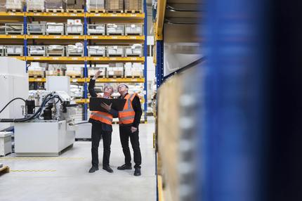 Bertelsmann Stiftung: Engineers standing with file folder and planning in factory || Modellfreigabe vorhanden