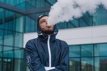 Vapen: Man smoking electronic cigarette vapor. Smoking Electronic Cigarette Man smoking electronic cigarette vapor. Smoking Electronic Cigarette against the background of a glass building Copyright: xx 37875334