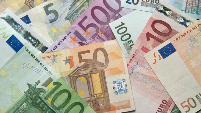 Haushalte: Zahlreiche Euro-Banknoten liegen auf einem Tisch.