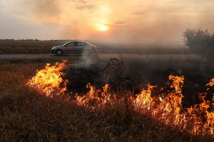 Lage in der Ukraine: A person drives a car along a road while roadside burns after a Russian military strike outside the town of Pokrovsk, amid Russia's attack on Ukraine, in Donetsk region, Ukraine September 17, 2024. REUTERS/Anton Shynkarenko TPX IMAGES OF THE DAY