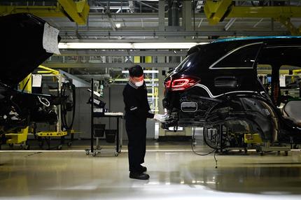 Autoindustrie: An employee wearing a face mask works on a production line at a Mercedes Benz automotive plant during a media tour organised by the government in Beijing on May 13, 2020, as the country's industrial sector starts again following shutdowns during the COVID-19 coronavirus outbreak. (Photo by WANG Zhao / AFP) (Photo by WANG ZHAO/AFP via Getty Images)