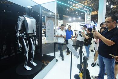 Посетители осматривают гуманоидного робота Tesla Optimus на Всемирной конференции по искусственному интеллекту 2023 года в Шанхае, Китай, 6 июля 2023 года. Рост андроида — 172 см, он весит 56,6 кг. Робот имеет 28 сочленений, имитирующих суставы человеческ