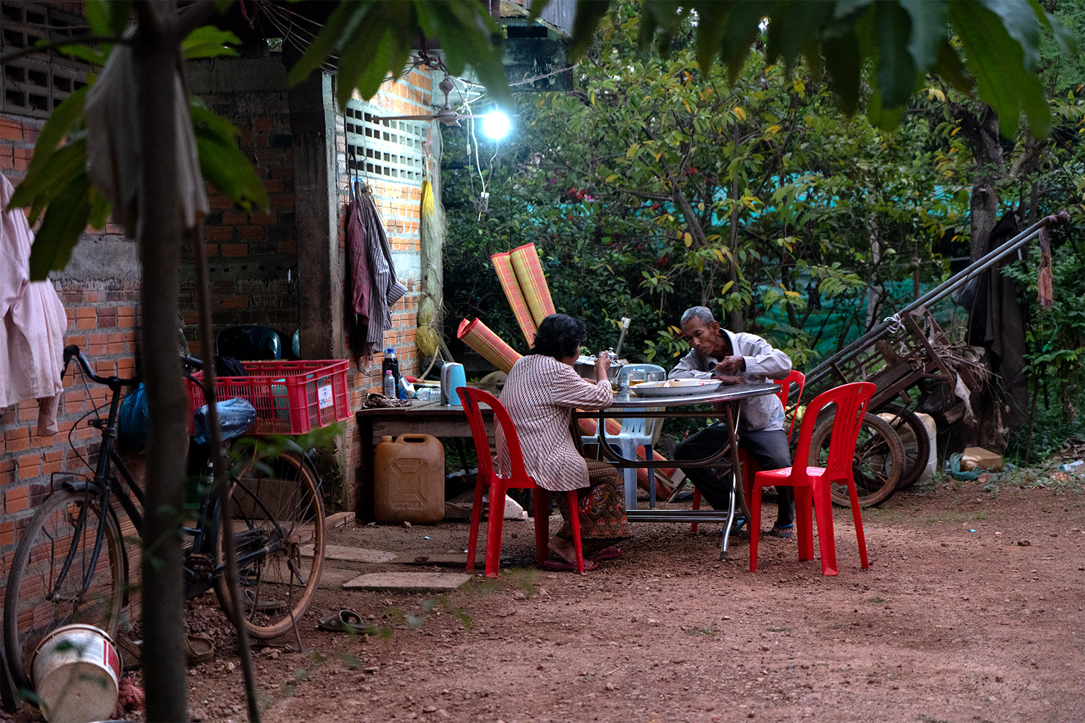 Rice farmers Im Kim San and Mia Tunn have dinner.