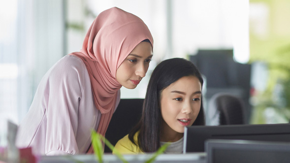 Dos mujeres mirando la pantalla de una laptop