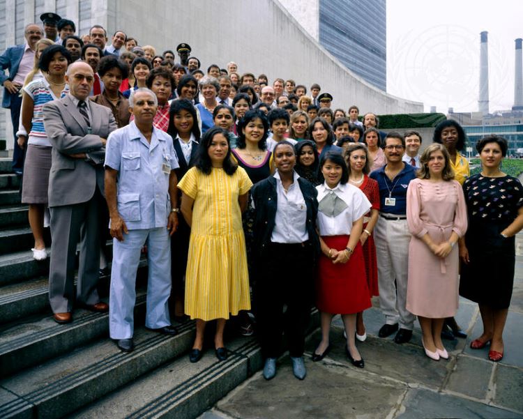 A group of United Nations staff stand on the steps in front of UN Headquarters in New York.