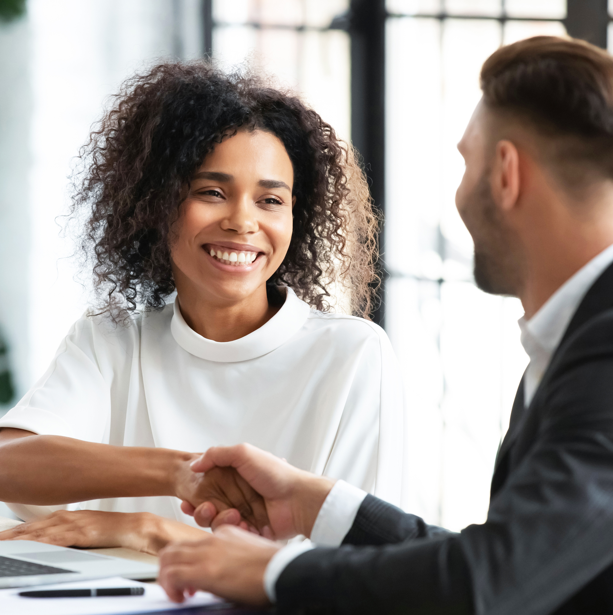 Digital marketing consultant shaking their client's hand at a meeting