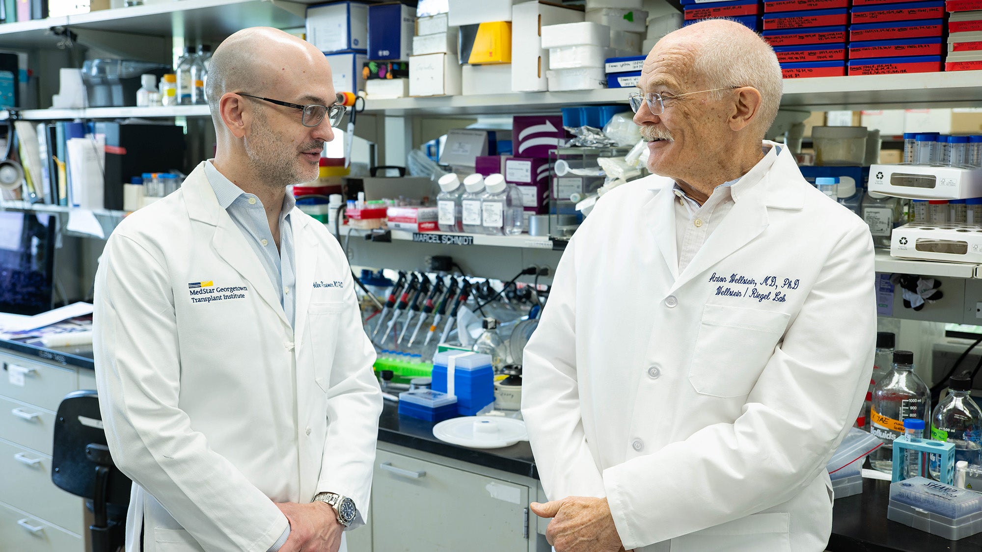 Dr. Kroemer and Dr. Wellstein talk in a lab