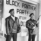 Founding members Bobby Seale (Courtney B. Vance) and Huey Newton (Marcus Chong) keep watch in front of Black Panther headquarters.