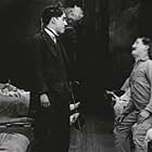 Charles Chaplin and James T. Kelley in Triple Trouble (1918)
