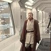 Jedi Obi-Wan Kenobi (actor Ewan McGregor) walks down a corridor, amazed by what he sees in the huge cloning facility on the planet Kamino. He is followed by Prime Minister Lama Su and aide Taun We.