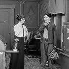 Charles Chaplin and Helen Carruthers in The New Janitor (1914)