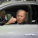 Joe Biden sits in an electric vehicle.