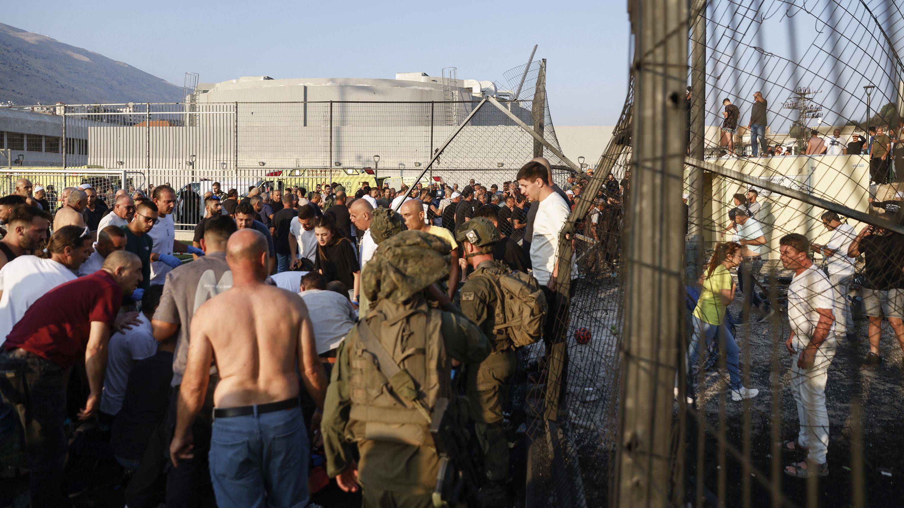 Israeli security forces and local residents gather at a site where a reported strike from Lebanon fell in Majdal Shams village in the Israeli-annexed Golan area on Saturday.