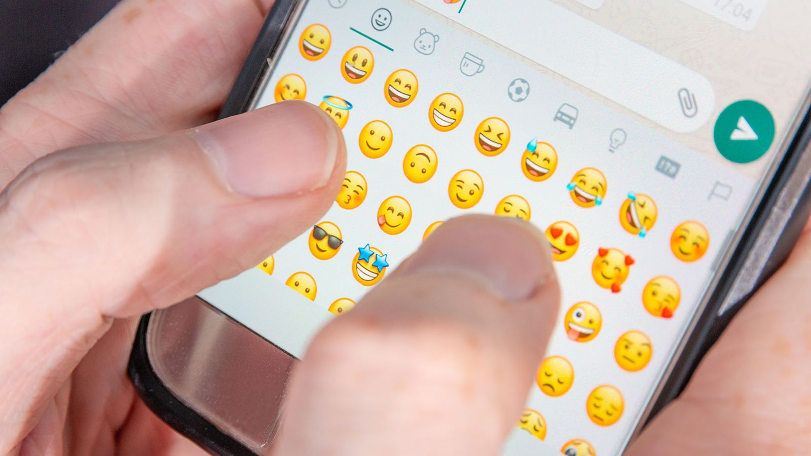 W2W5YH A person typing emoji characters into a chat app