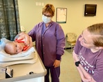 Blanchfield Army Community Hospital's Women's Health team weighs a infant.