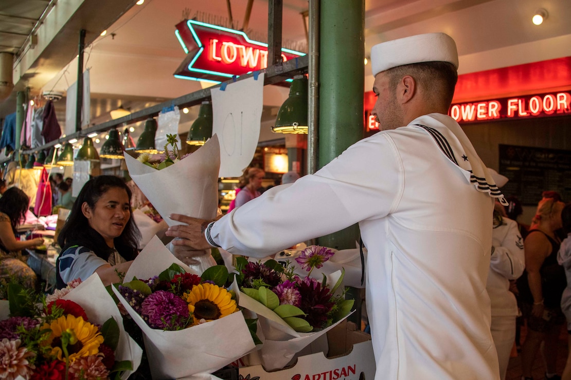230802-N-YF131-1090 SEATTLE (Aug. 2, 2023) Cryptologic Technician (Collection) Seaman Kaden Boyce, from Front Royal, Va., assigned to the Arleigh Burke-class guided missile destroyer USS Barry (DDG 52) buys flowers at Pike Place Market during Seattle Fleet Week, Aug. 2, 2023. Seattle Fleet Week is a time-honored celebration of the sea services and provides an opportunity for the citizens of Washington to meet Sailors, Marines and Coast Guardsmen, as well as witness firsthand the latest capabilities of today’s U.S. and Canadian maritime services. (U.S. Navy photo by Mass Communication Specialist 2nd Class Madison Cassidy)