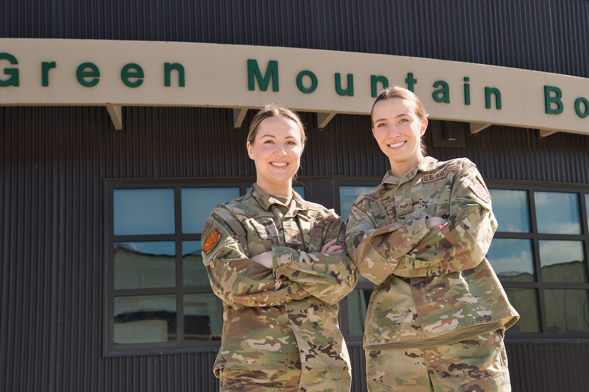 Photo of U.S. Air Force Staff Sgt. Sarah Gerry (left), an armament systems loader at the 158th Fighter Wing, and her sister, U.S. Air Force Senior Airman Laura Gerry, a munitions systems storage handler at the 158th Fighter Wing, standing together for a photo at the Vermont Air National Guard Base, South Burlington, Vermont, April 8, 2024.