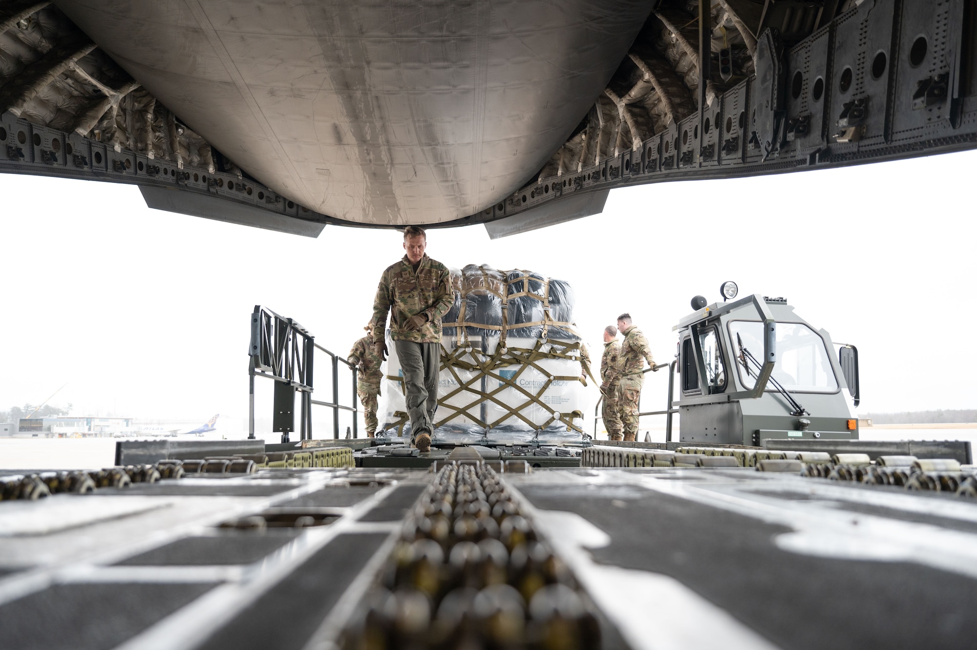 Tech. Sgt. Connor Collins, a loadmaster with the 167th Airlift Wing, guides a pallet onto the C-17 Globemaster III March 15, 2024, at Pease Air National Guard Base, New Hampshire. The joint team utilized a wealth of transportation and aviation knowledge to safely prepare and load the equipment.